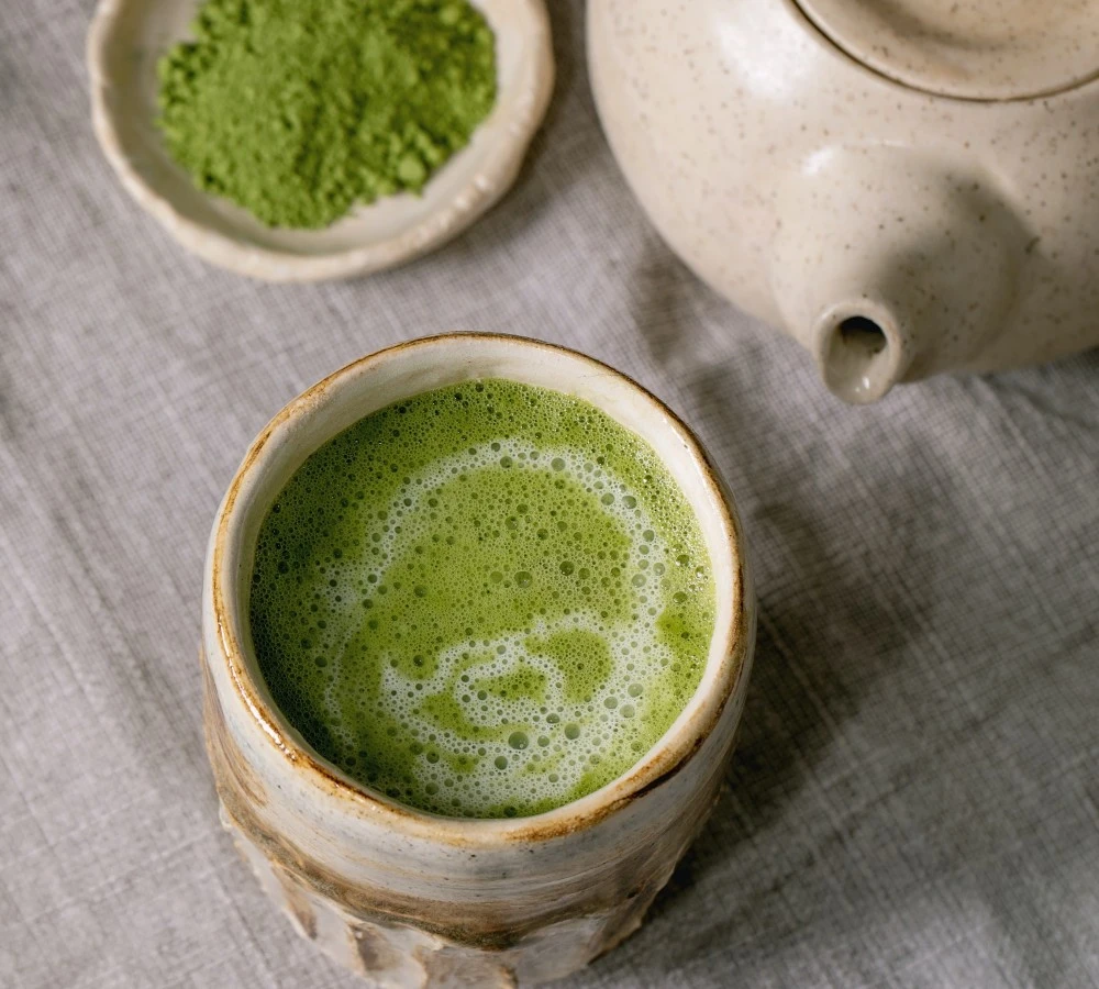 matcha tea in a cup with teapot