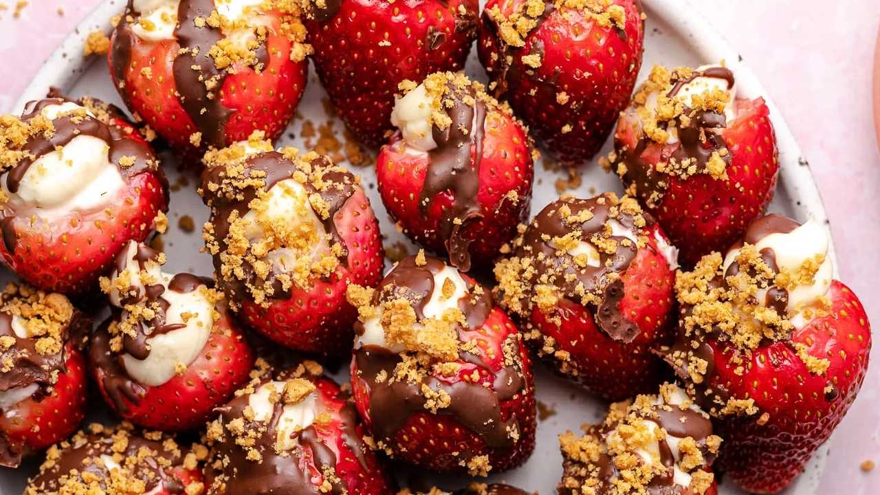 strawberries stuffed with cream cheese with chocolate drizzle and graham cracker dust