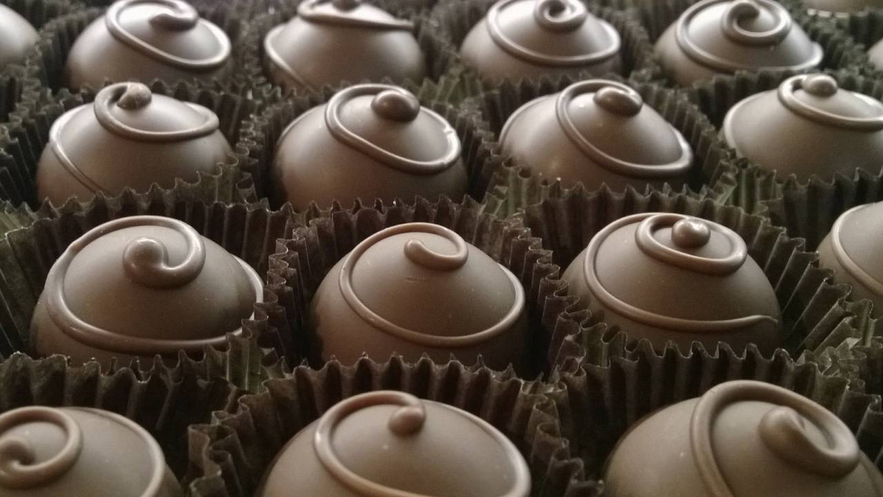 chocolate candies in paper in rows