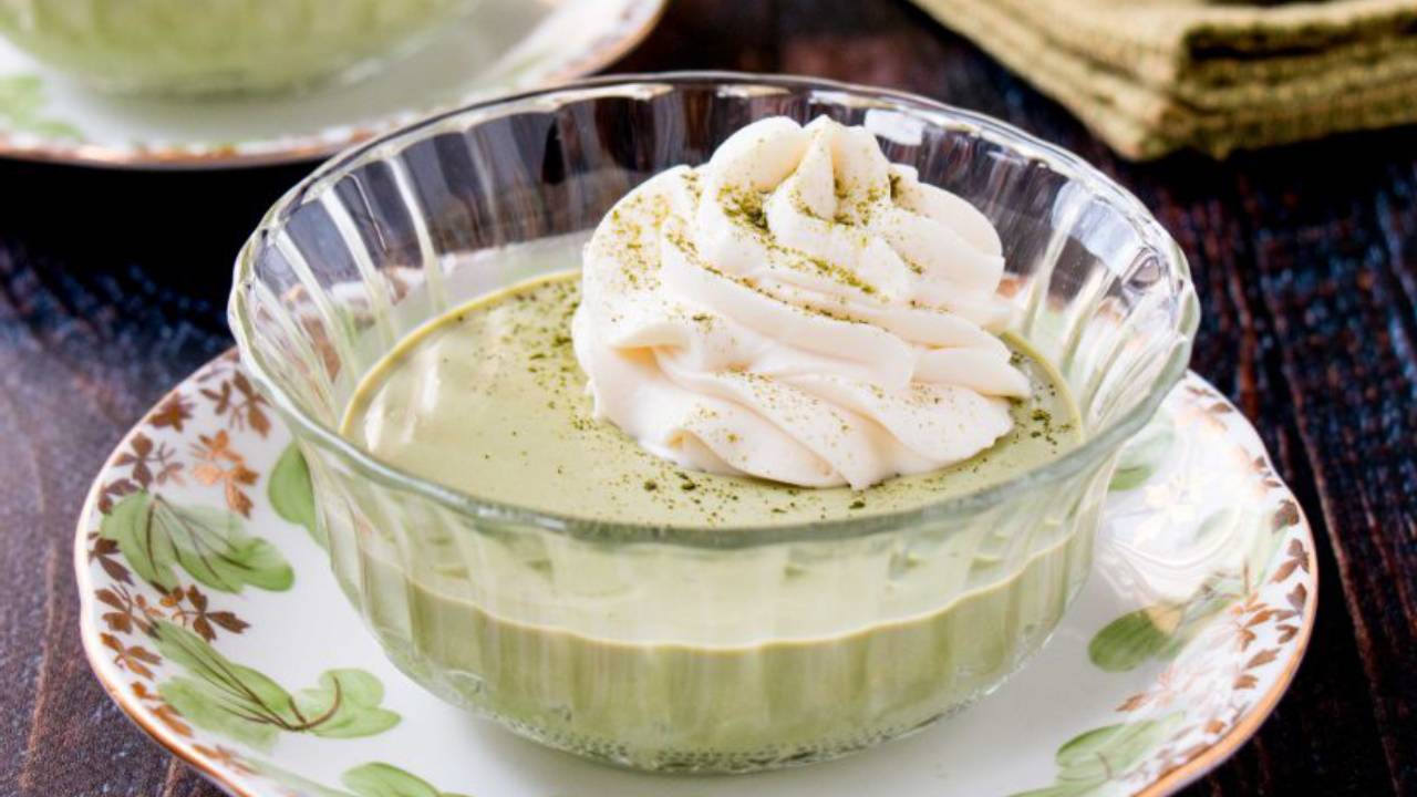matcha pudding in a bowl with a white cream topping