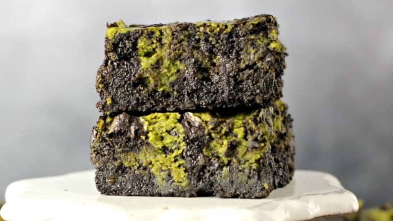 matcha cheesecake brownies on a plate stand