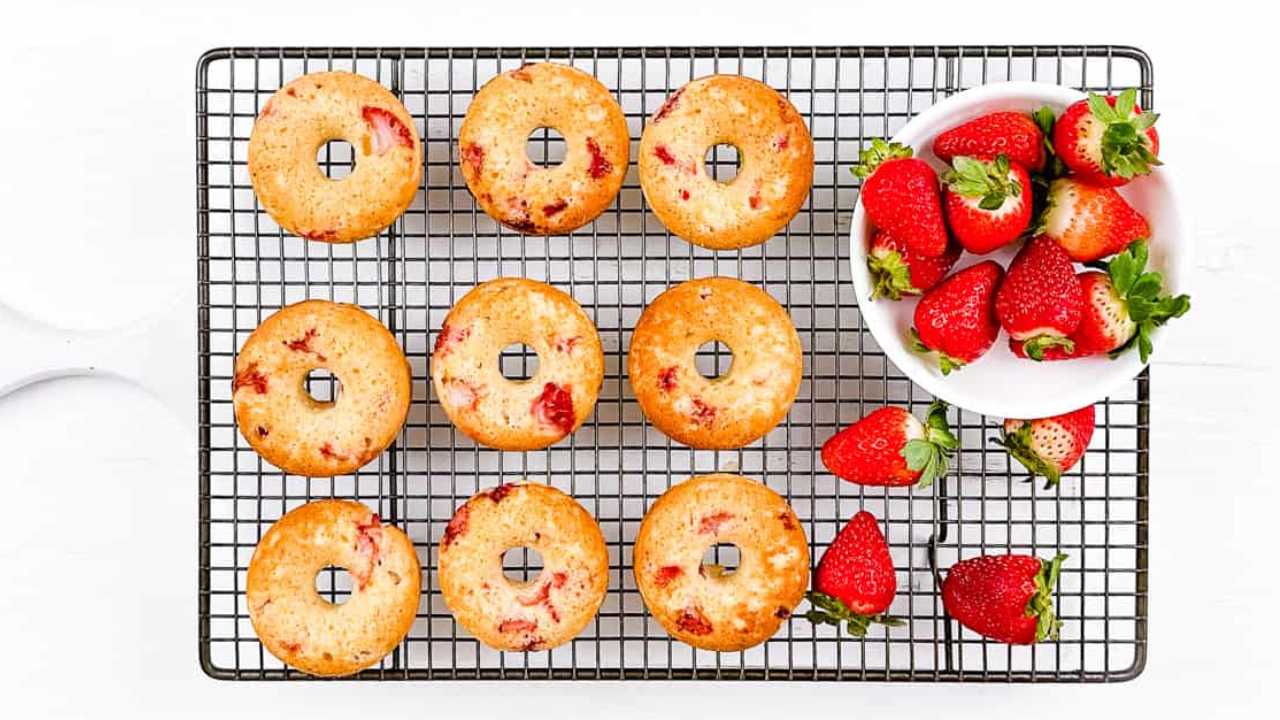 strawberry donuts on a baking rack